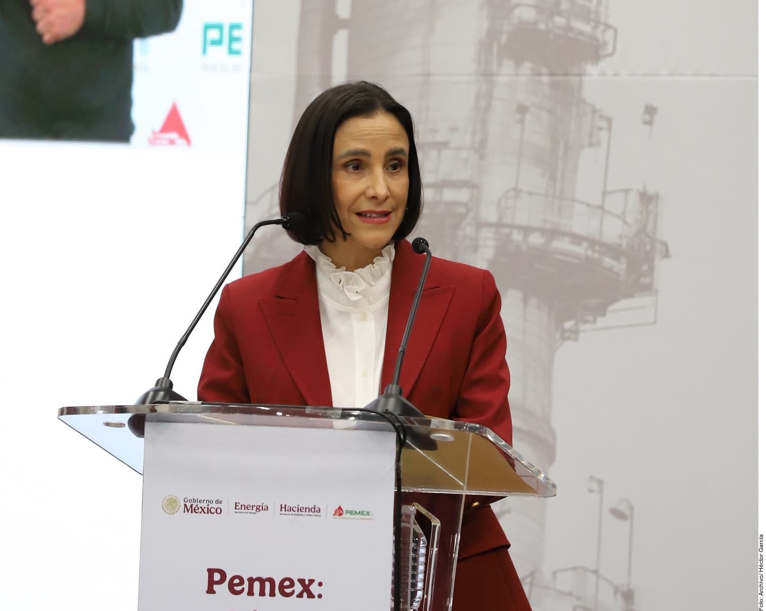 Funcionaria en podio con logotipo de Pemex y emblemas del Gobierno de México, Energía y Hacienda durante presentación oficial.