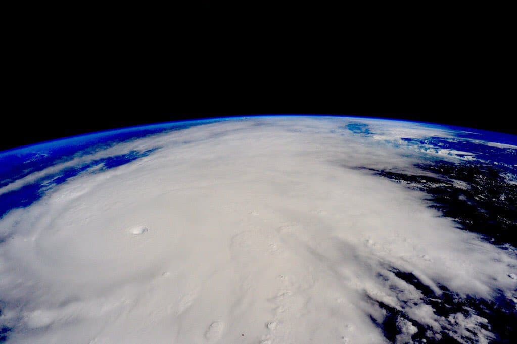 Imagen satelital de un sistema ciclónico con estructura definida y ojo visible sobre el océano, con la curvatura terrestre y atmósfera de fondo.